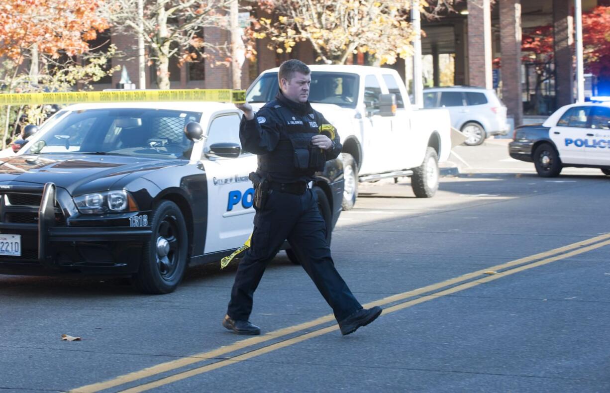 A police officer puts up police tape at the scene of a reported shootingin downtown Vancouver on Wednesday.