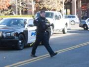 A police officer puts up police tape at the scene of a reported shootingin downtown Vancouver on Wednesday.