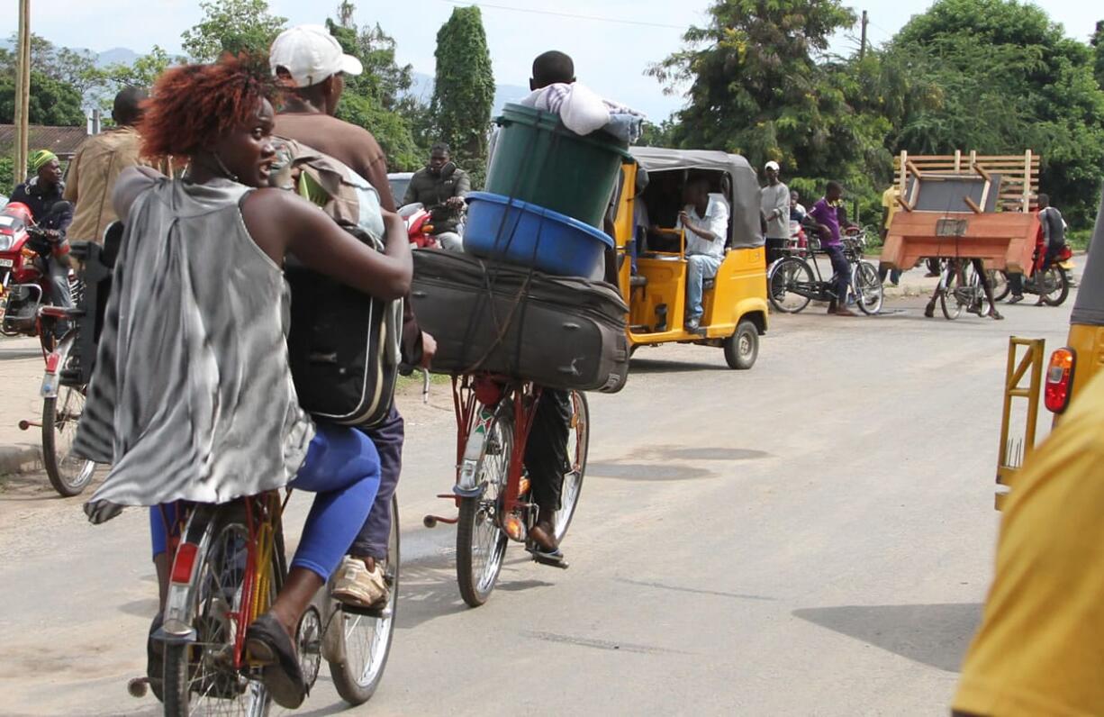 Burundians carry their belongings on bicycles Saturday in Bujumbura, Burundi, as many people fled the capital before a security crackdown.