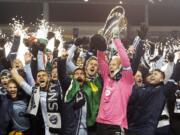 Sporting Kansas City goalkeeper Jimmy Nielsen, center, hoists the MLS Cup as he and his teammates celebrate their 2-1 win over Real Salt Lake on Saturday.