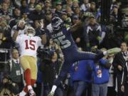 Seattle Seahawks' Richard Sherman tips a pass intended for San Francisco 49ers' Michael Crabtree (15) in the final seconds of the second half of the NFL football NFC Championship game Sunday, Jan. 19, 2014, in Seattle. Malcolm Smith intercepted the tipped pass. The Seahawks won 23-17 to advance to Super Bowl XLVIII.