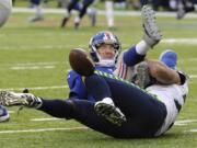 Seattle Seahawks defensive end Michael Bennett, bottom, forces a fumble off New York Giants quarterback Eli Manning  during the second half on Sunday.