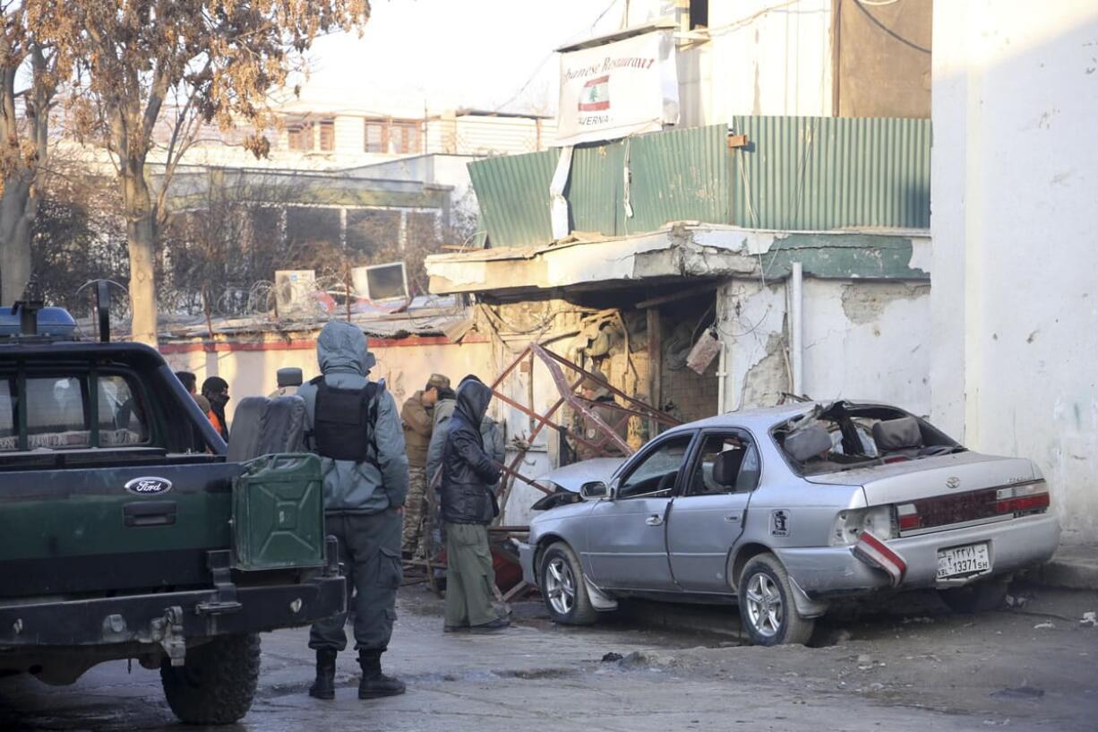 Afghan security forces personnel investigate Saturday at the site of the Friday's suicide attack and shooting, in Kabul, Afghanistan.