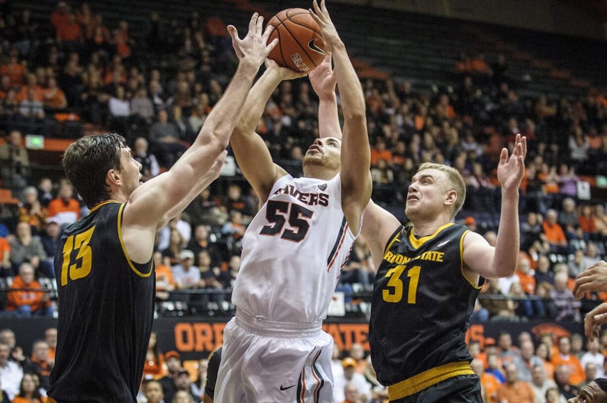 Oregon State's Roberto Nelson, shoots over Arizona State's Jordan Bachynski, left and Jonathon Gilling, right, during the second half of an NCAA college basketball game in Corvallis, Ore., Saturday March 8 2014.