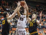 Oregon State's Roberto Nelson, shoots over Arizona State's Jordan Bachynski, left and Jonathon Gilling, right, during the second half of an NCAA college basketball game in Corvallis, Ore., Saturday March 8 2014.