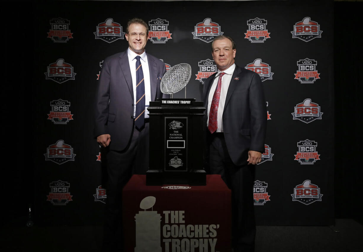 Auburn head coach Gus Malzahn, left, and Florida State head coach Jimbo Fisher pose with The Coaches' Trophy during a news conference for the NCAA BCS National Championship college football game Sunday, Jan. 5, 2014, in Newport Beach, Calif. Florida State plays Auburn on Monday, Jan. 6, 2014. (AP Photo/David J.