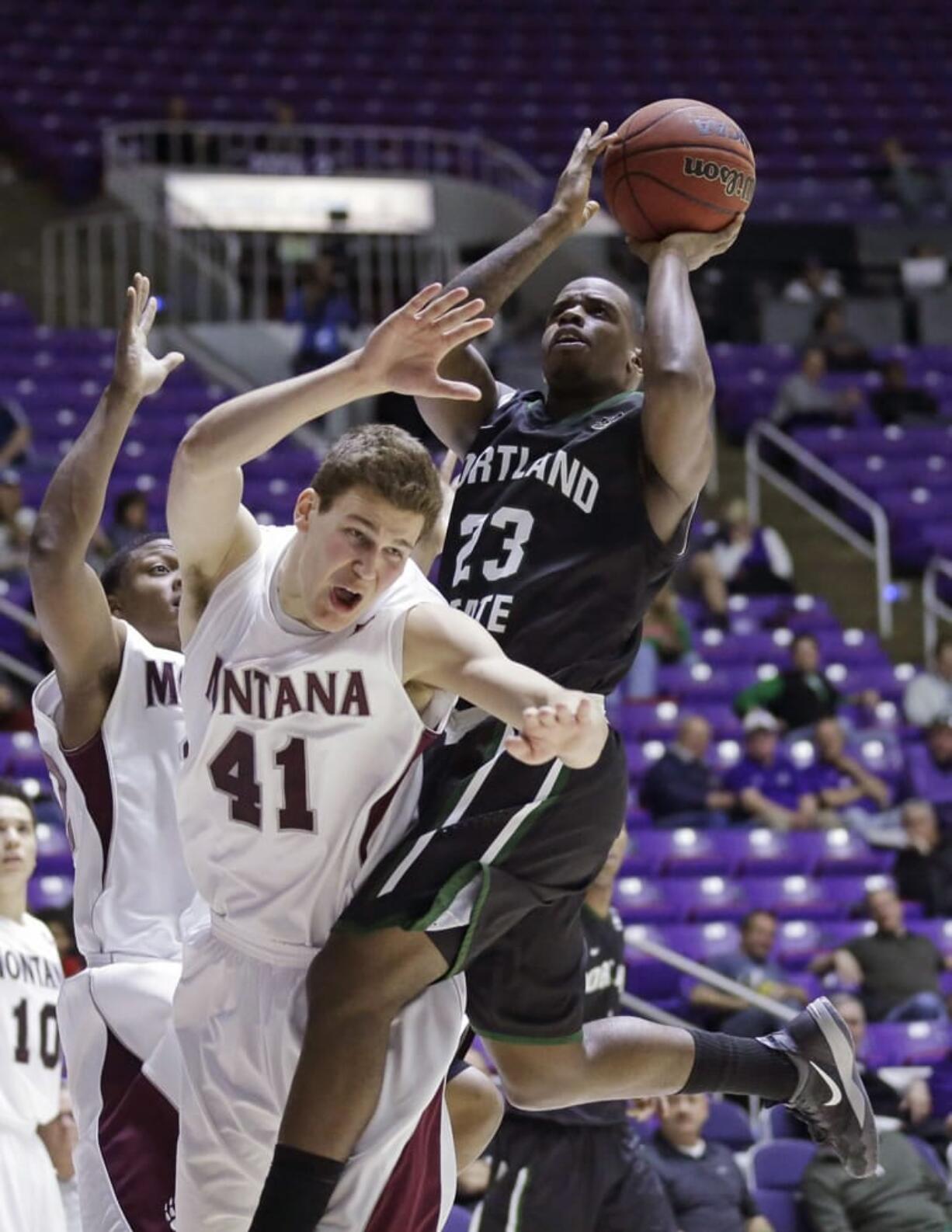 Portland State's DaShaun Wiggins (23) goes to the basket as Montana's Andy Martin (41) defends during the Big Sky quarterfinals in Ogden, Utah.