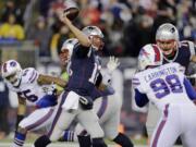 New England Patriots quarterback Tom Brady (12) passes against pressure from Buffalo Bills defensive end Alex Carrington (98) in the first half of an NFL football game Monday, Nov. 23, 2015, in Foxborough, Mass.