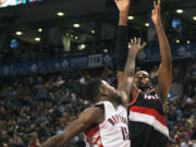 Portland Trail Blazers' LaMarcus Aldridge goes up for a shot against Toronto Raptors' Amir Johnson on Sunday. Aldridge had his fifth consecutive double-double with 25 points and 11 rebounds in Portland's 118-110 overtime victory at Toronto.