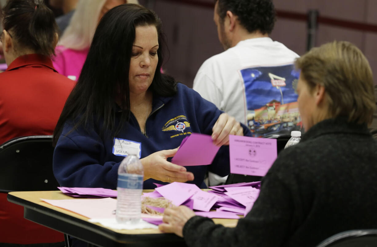 Volunteer vote counters tally ballots Friday at the Boeing Machinists union hall in Seattle.