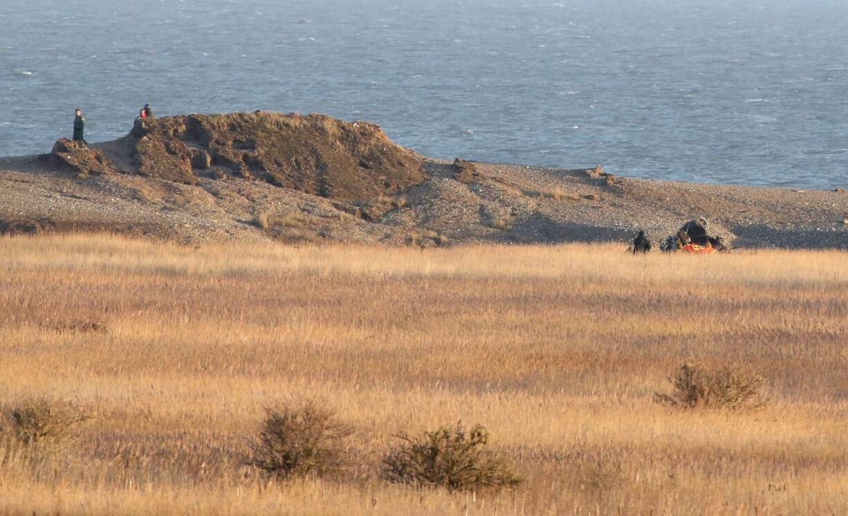 The wreckage of a US Military Air Force Pave Hawk helicopter, at right, lies on the ground in Salthouse, England, on Wednesday.