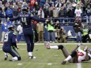 Seattle Seahawks' kicker Steven Hauschka (4) watches as his game-winning field goal is good in overtime as holder Jon Ryan watches the ball and Tampa Bay Buccaneers' Johnthan Banks, right, goes to the turf in an NFL football game Sunday, Nov. 3, 2013, in Seattle. The Seahawks won 27-24 in overtime.