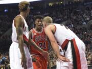 Chicago Bulls guard Jimmy Butler (21) and Portland Trail Blazers center Mason Plumlee (24) exchange words during the fourth quarter of an NBA basketball game in Portland, Ore., Tuesday, Nov 24, 2015. The Bulls won 93-88.