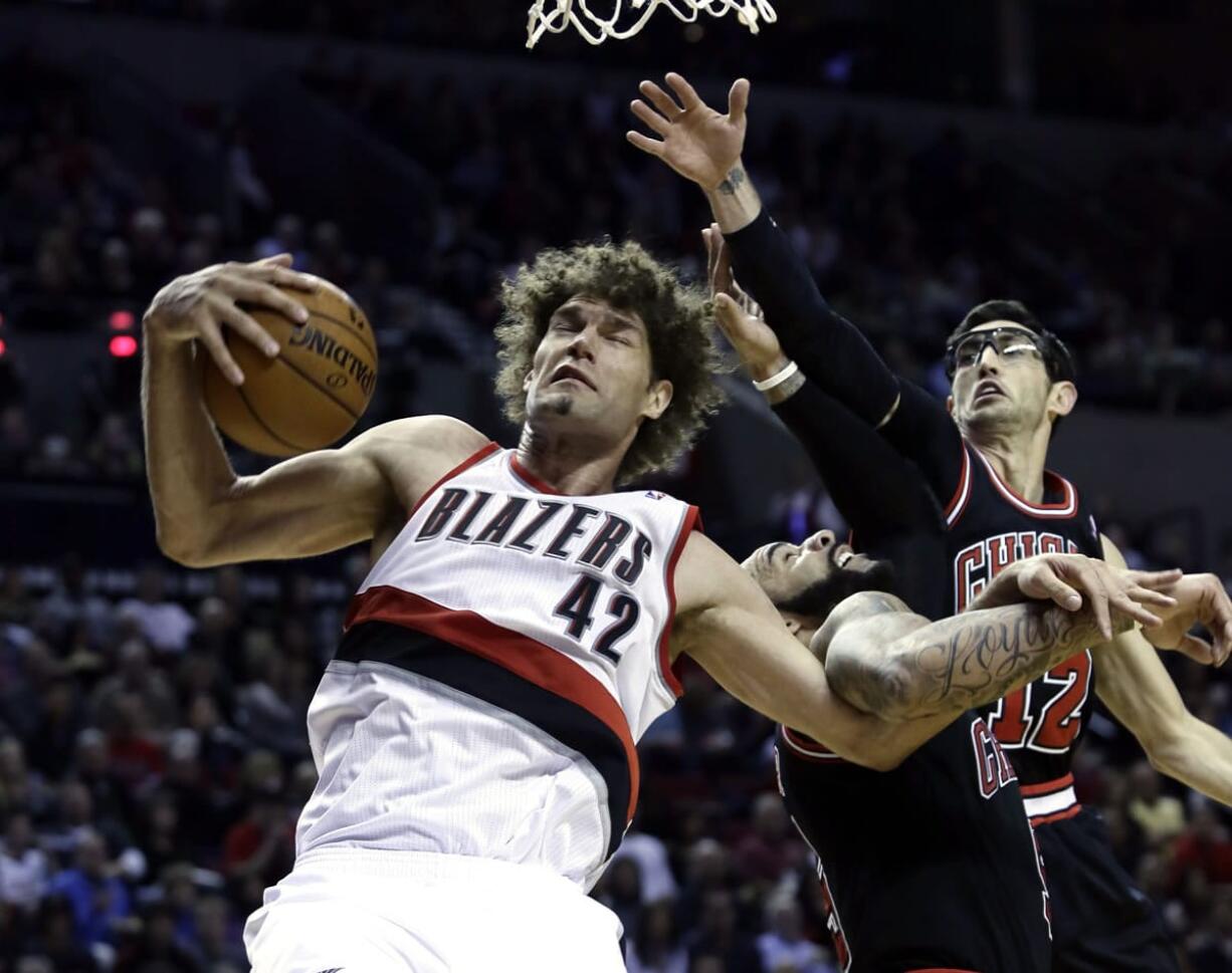 Blazers center Robin Lopez, left, pulls in an offensive rebound against the Chicago Bulls' Kirk Hinrich, right, and Carlos Boozer during the second half Friday.