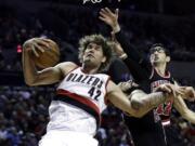 Blazers center Robin Lopez, left, pulls in an offensive rebound against the Chicago Bulls' Kirk Hinrich, right, and Carlos Boozer during the second half Friday.