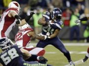 Seattle Seahawks running back Marshawn Lynch (24) rushes as Arizona Cardinals strong safety Tony Jefferson (22) attempts the tackle in the first half of an NFL football game Sunday, Nov. 15, 2015, in Seattle.