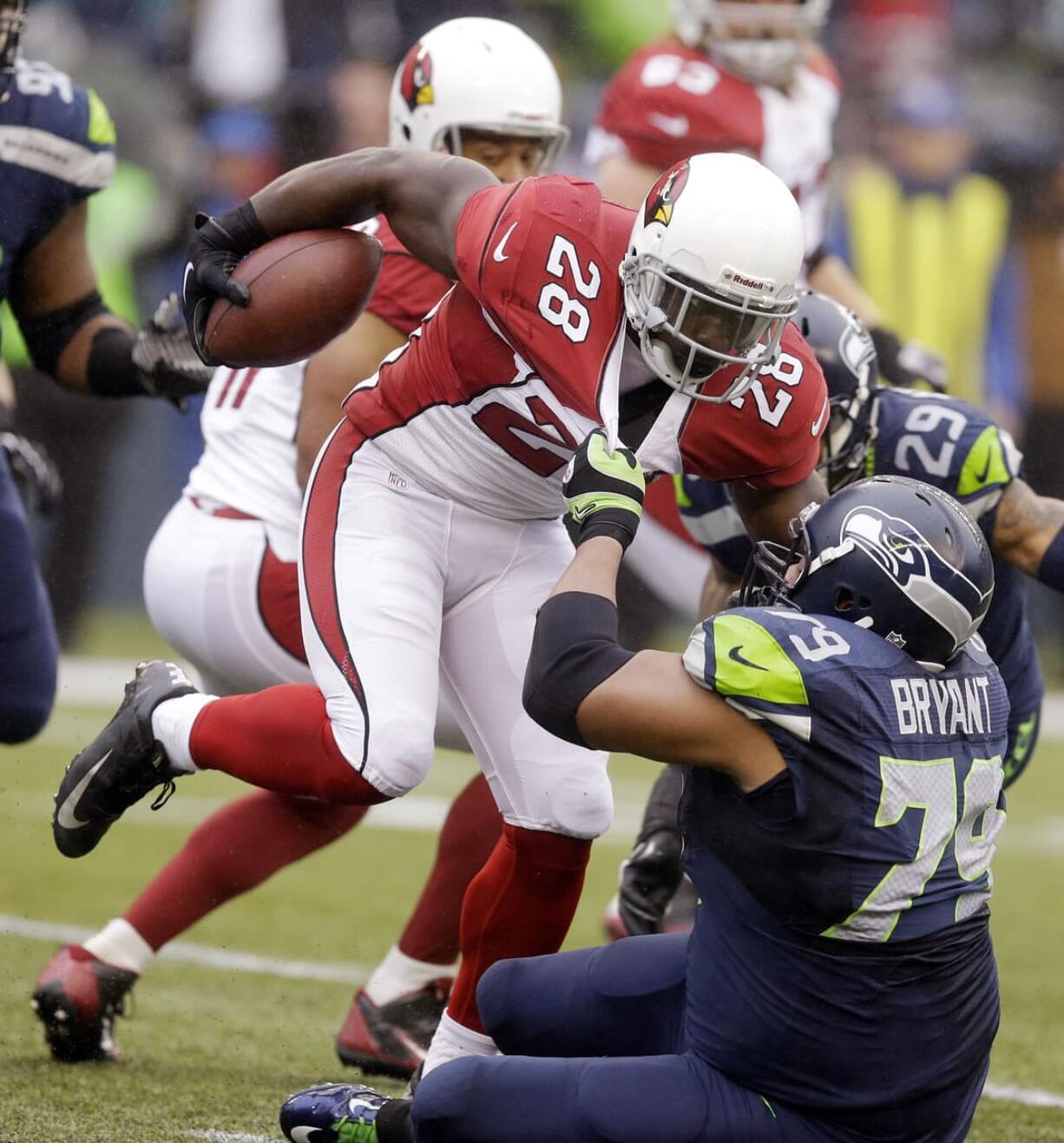 Seattle Seahawks' Red Bryant (79) pulls down Arizona Cardinals' Rashard Mendenhall on a run in the first half Dec.