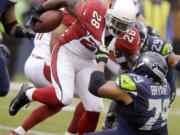 Seattle Seahawks' Red Bryant (79) pulls down Arizona Cardinals' Rashard Mendenhall on a run in the first half Dec.