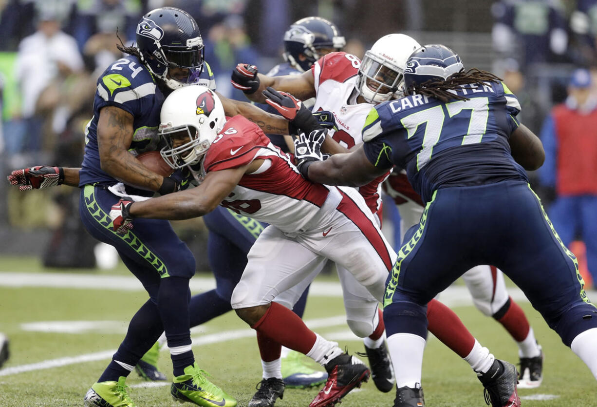 Seattle's Marshawn Lynch, left, is tackled by Arizona's Jake Ballard in Sunday's game.