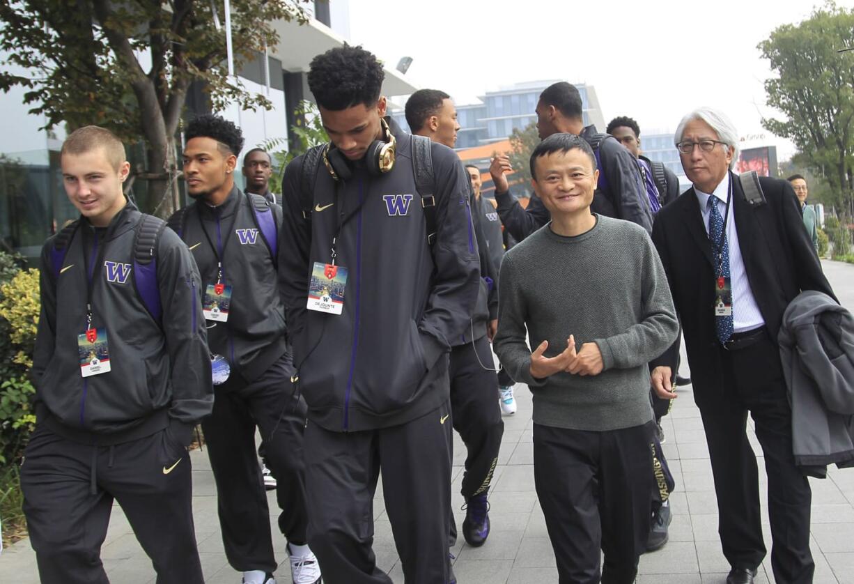 Jack Ma, second from right, executive chairman of the Alibaba Group, walks with players from the University of Washington men's basketball team in Hangzhou in eastern China's Zhejiang province Tuesday, Nov. 10, 2015.