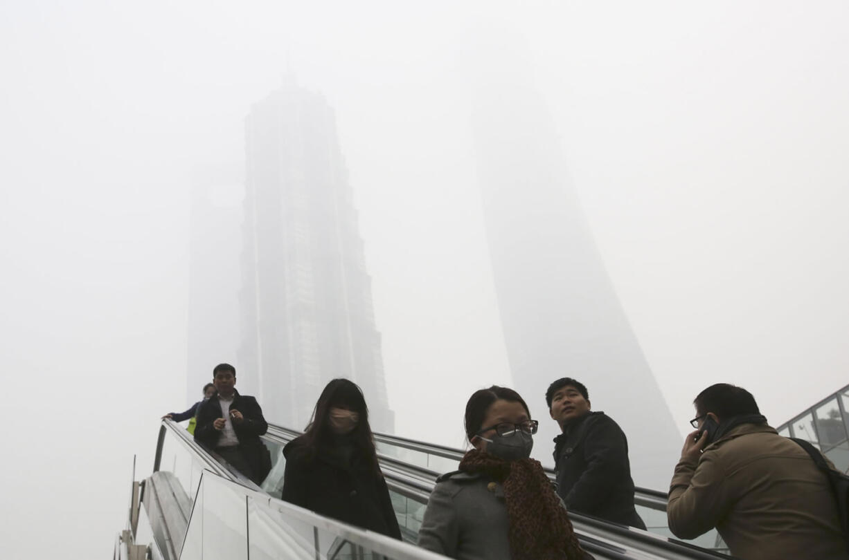 People on escalators wear masks Friday in Shanghai as China's financial hub suffered one of its worst bouts of air pollution.