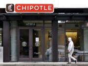 A pedestrian walks past a closed Chipotle restaurant Monday in Seattle.