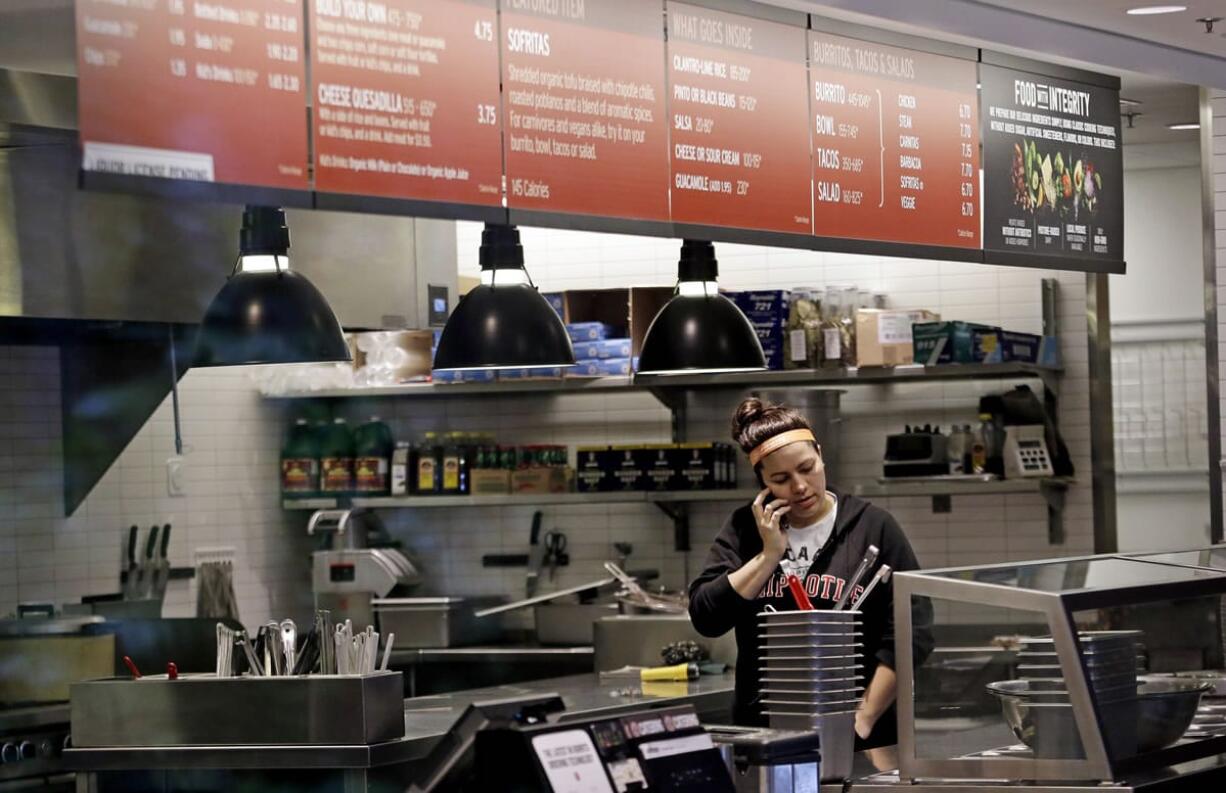 A woman talks on the phone as she stands in the kitchen area of a closed Chipotle restaurant Mondayin Seattle. An E. coli outbreak linked to Chipotle restaurants in Washington state and Oregon has sickened nearly two dozen people in the third outbreak of foodborne illness at the popular chain this year. Cases of the bacterial illness were traced to six of the fast-casual Mexican food restaurants, but the company voluntarily closed down 43 of its locations in the two states as a precaution.