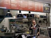 A woman talks on the phone as she stands in the kitchen area of a closed Chipotle restaurant Mondayin Seattle. An E. coli outbreak linked to Chipotle restaurants in Washington state and Oregon has sickened nearly two dozen people in the third outbreak of foodborne illness at the popular chain this year. Cases of the bacterial illness were traced to six of the fast-casual Mexican food restaurants, but the company voluntarily closed down 43 of its locations in the two states as a precaution.