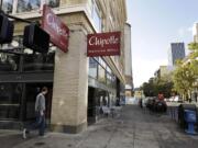 A pedestrian walks past a closed Chipotle restaurant in Portland on Monday. Chipotle voluntarily closed down 43 of its locations in Washington and in the Portland area as a precaution after an E. coli outbreak linked to six of its restaurants in the two states has sickened nearly two dozen people.