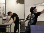 Workers clean inside a still-closed Chipotle restaurant Monday in Seattle. Health officials in Washington and Oregon have said that more than three dozen people have gotten sick with E. coli in an outbreak linked to Chipotle restaurants in the two states. More than 40 Chipotle restaurants remain closed in Washington state and the Portland area while authorities search for the cause.