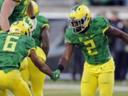 Oregon wide receiver Bralon Addison, right, shakes hands with teammate Charles Nelson after scoring a touchdown in the second half  of an NCAA college football game against Oregon State, in Eugene Ore., on Friday, Nov. 27, 2015. Oregon won 52-42. (AP Photo/Timothy J.