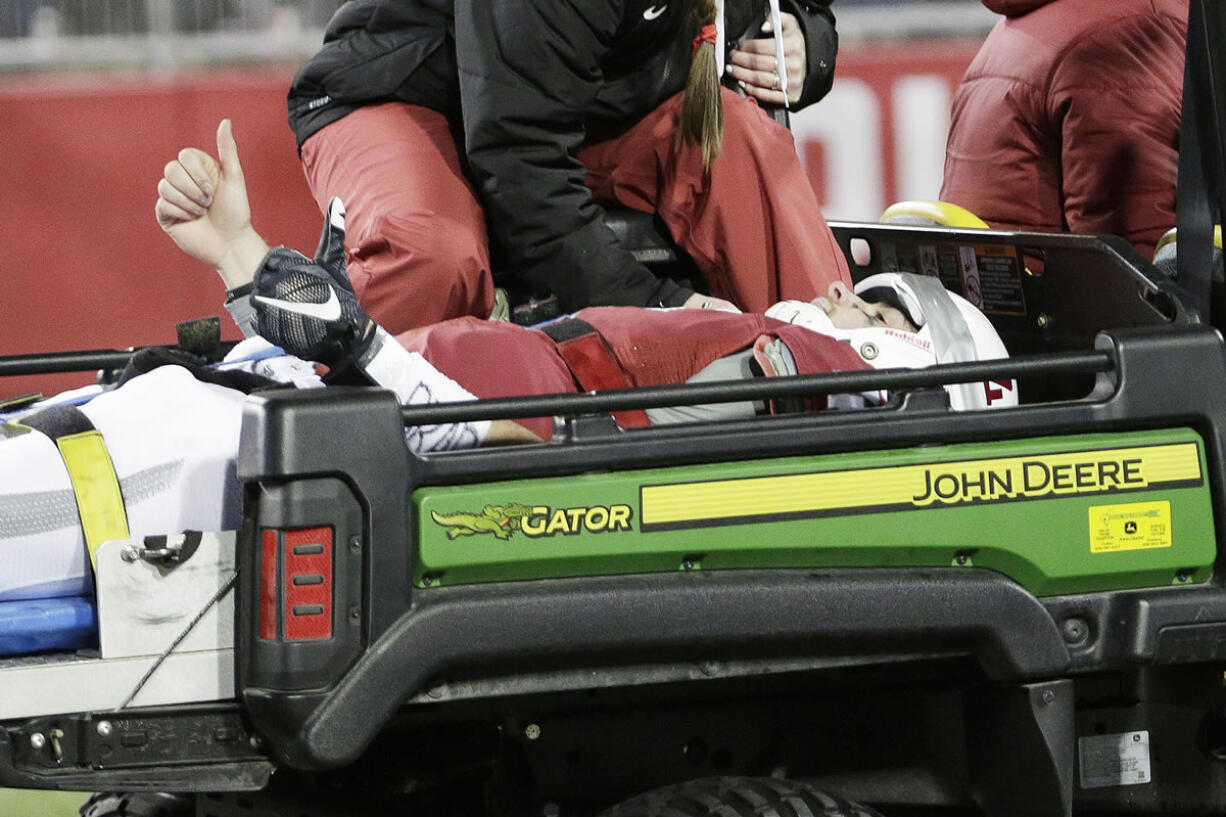 Washington State quarterback Luke Falk (4) gestures as he is carted off the filed after being injured during the second half of an NCAA college football game against Colorado, Saturday, Nov. 21, 2015, in Pullman, Wash. Washington State won 27-3.