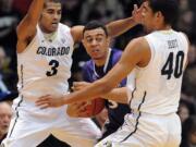 Xavier Talton, left, of Colorado, and Josh Scott (40), trap Nigel Williams-Goss of Washington during the first half of an NCAA college basketball game in Boulder, Colo., Sunday, Feb. 9, 2014.