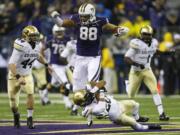 Washington tight end Austin Seferian-Jenkins (88) is tackled by the leg by Colorado defensive back Greg Henderson, bottom, as Colorado's Addison Gillam (44) looks on in the first half of an NCAA college football game on Saturday, Nov. 9, 2013, in Seattle. (AP Photo/Ted S.