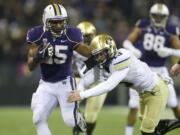 Washington running back Bishop Sankey pushes Colorado defensive back Parker Orms, right, out of the way in the first half Saturday in Seattle.