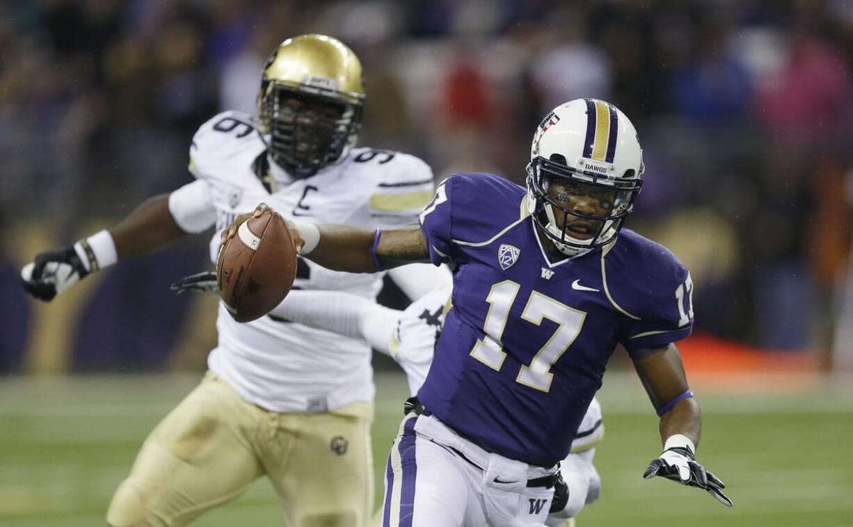 Washington quarterback Keith Price (17) scrambles away from Colorado defensive lineman Chidera Uzo-Diribe, left, in the first half of an NCAA college football game on Saturday, Nov. 9, 2013, in Seattle. (AP Photo/Ted S.