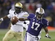 Washington quarterback Keith Price (17) scrambles away from Colorado defensive lineman Chidera Uzo-Diribe, left, in the first half of an NCAA college football game on Saturday, Nov. 9, 2013, in Seattle. (AP Photo/Ted S.