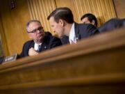 In this July 9, 2014, file photo, Senate Foreign Relations Committee members Sen. Tim Kaine, D-Va., left, and Sen. Christopher Murphy, D-Conn., participate in a committee hearing on Capitol Hill in Washington. In the fight against the Islamic State group, members of Congress talk tough on extremism, but most want nothing to do with voting to legally authorize the military campaign, preferring to let the president take ownership of the mission.