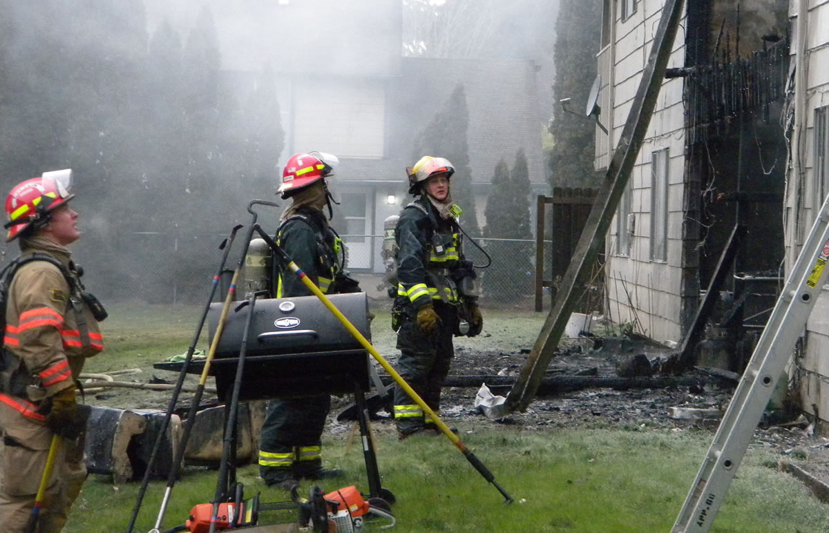 Firefighters work at the scene of an apartment complex fire in Vancouver's Ogden neighborhood this morning.