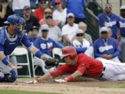 Los Angeles Dodgers catcher A.J. Ellis tags out Los Angeles Angels' Mike Trout at home during the first inning of an exhibition spring training baseball game Thursday, March 6, 2014, in Tempe, Ariz. Trout tried to stretch a triple into an inside the park home run.