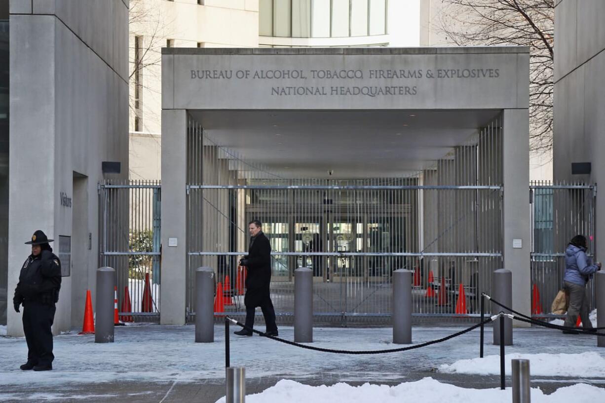 In this Thursday, Jan. 23, 2014 photo, a security official walks in front of the entrance to the national headquarters of the Bureau of Alcohol, Tobacco, Firearms and Explosives in Washington. Illinoisi two U.S. senators have proposed renaming the building after prohibition-era crime fighter Eliot Ness, but it won't happen if Ed Burke, the dean of the Chicago City Council and others have their way. Portrayed over the years by Kevin Costner and Robert Stack as an incorruptible hero, Ness' legend is now at risk, with some claiming his role in taking out Chicago mobster Al Capone is as mythical as Mrs. OiLearyis cow starting the Great Chicago Fire.