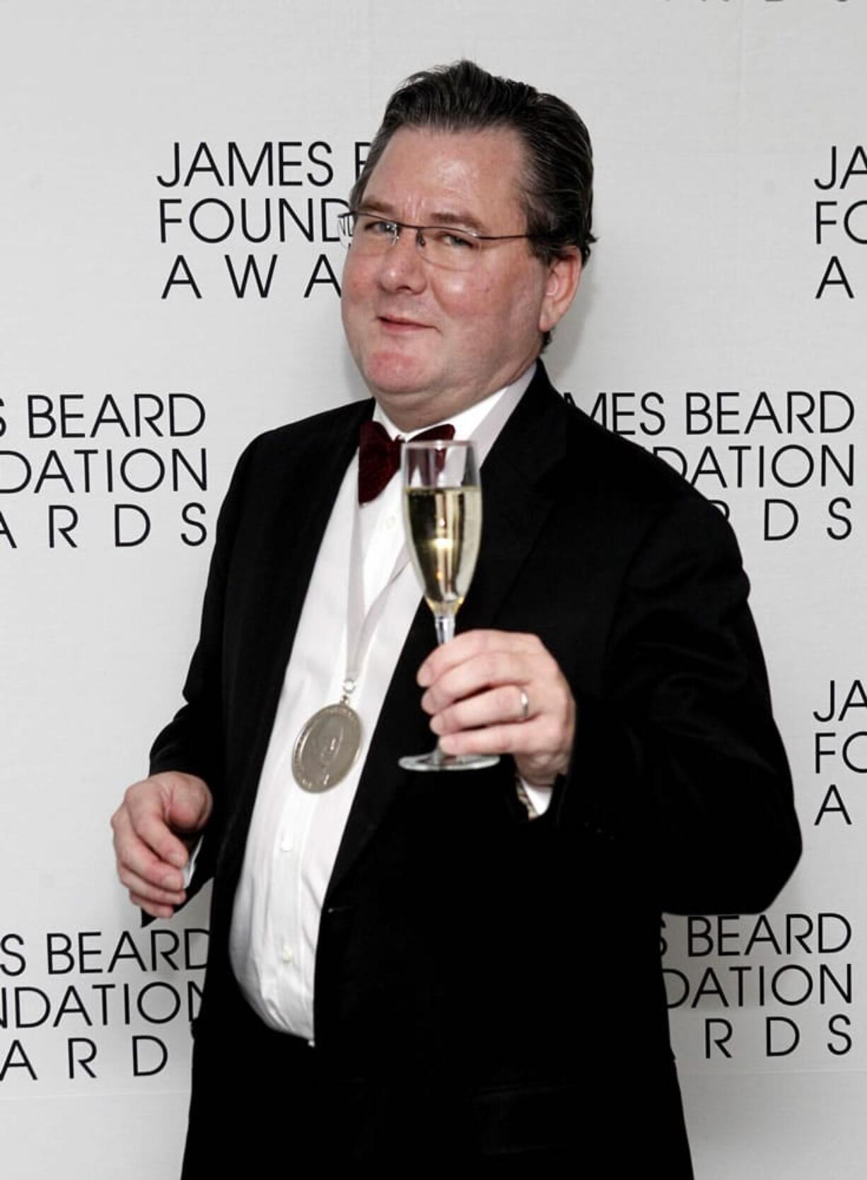 FILE - In this May 7, 2012 file photo, chef Charlie Trotter poses with a glass of champagne and his medal for Humanitarian of the Year during the James Beard Foundation Awards in New York. The award-winning chef died in November, a year after closing his eponymous Chicago restaurant that is credited with elevating the city's cuisine and providing a training ground for some of the nation's other best chefs.