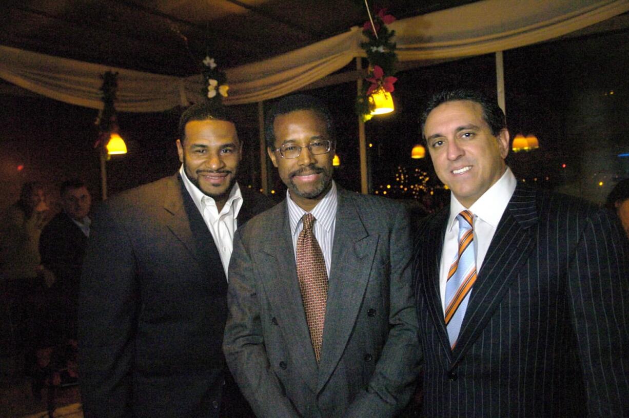 Dr. Ben Carson, center, flanked by Dr. Al Costa, right, and then Pittsburgh Steelers running back, Jerome Bettis pose at the The Pittsburgh Carson Scholars Fund 2nd Annual Charity Auction Cocktail Event in Pittsburgh in 2005. Republican presidential contender Carson has maintained a business relationship with Costa, a close friend convicted of defrauding insurance companies and testified on his behalf, even as the candidate has called for such crimes to be punished harshly.