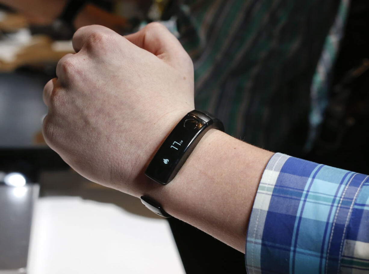 A member of the media tries on an LG Life Band Touch activity tracker during the 2014 Consumer Electronics Show on Monday in Las Vegas.