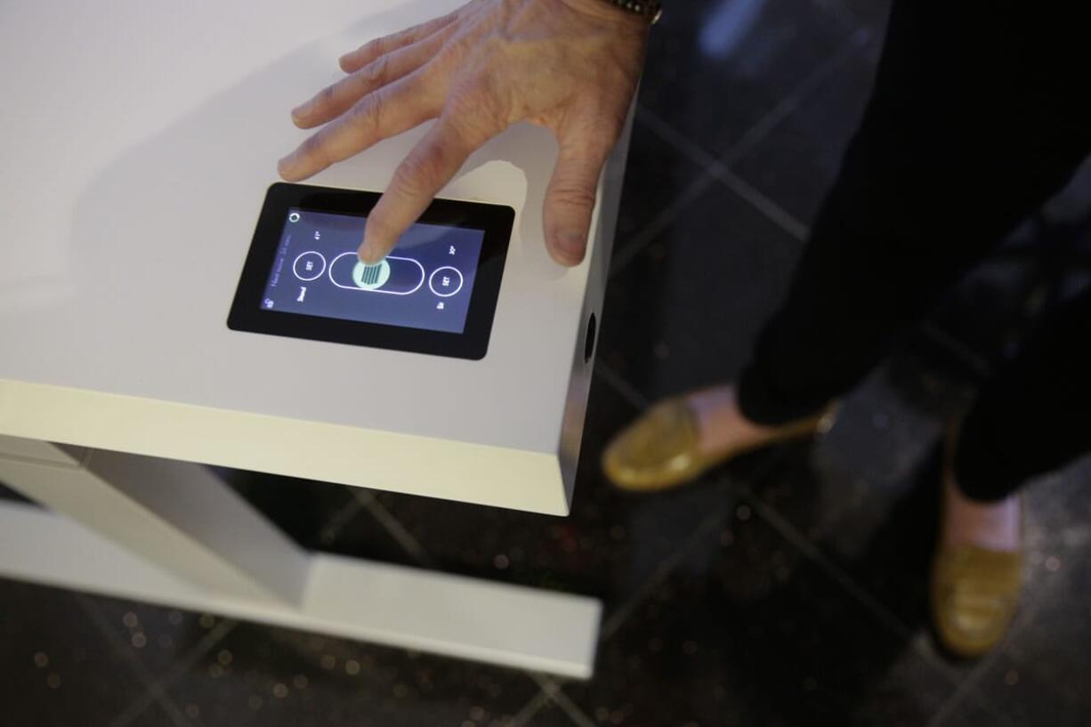 Jennifer McNally, a head of marketing at Stir, demonstrates the company's $3,890 Kinetic Desk on Wednesday at the International Consumer Electronics Show in Las Vegas.