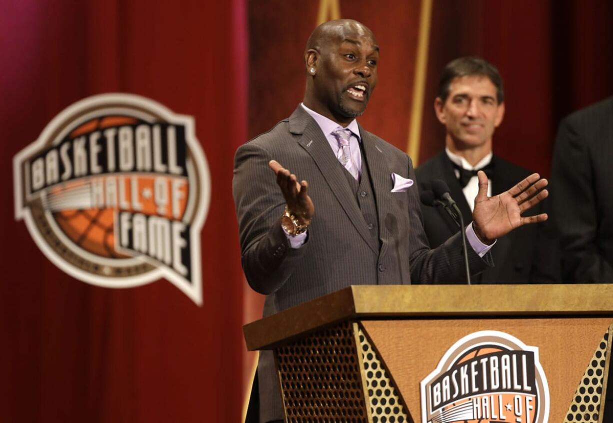 Inductee Gary Payton, left, speaks during the enshrinement ceremony for the 2013 class of the Naismith Memorial Basketball Hall of Fame as Hall of Famer John Stockton, right, looks on at Symphony Hall in Springfield, Mass., Sunday, Sept. 8, 2013.