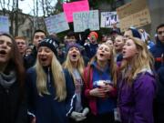 Students sing vocalist Mary Lambert's lyrics to the song &quot;Same Love&quot; by Macklemore &amp; Ryan Lewis outside of the Chancery building for the Archdiocese of Seattle, Friday, Dec. 20, 2013, in Seattle. The students were rallying for Eastside Catholic's Vice Principal Mike Zmuda, who resigned his position after officials with the archdiocese discovered that he was in a same-sex marriage. He was told the marriage violated his contract.