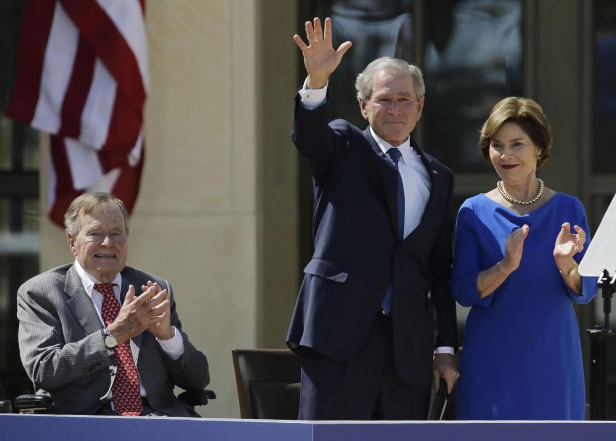 Former President George H.W. Bush, left, applauds with Laura Bush after former President George W. Bush&#039;s speech at the dedication of the George W. Bush Presidential Center in Dallas on April 25, 2013.