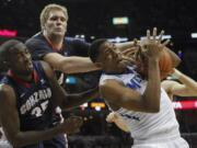 Memphis forward Nick King, right, tries to hang onto a rebound against Gonzaga center Sam Dower Jr. (35) and center Przemek Karnowski, back, in the second half Saturday. Memphis won 60-54.