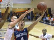 Gonzaga guard Kevin Pangos, center, puts up a shot as Pepperdine forward David Jesperson defends during the first half of an NCAA college basketball game, Thursday, Jan. 16, 2014, in Malibu, Calif. (AP Photo/Mark J.